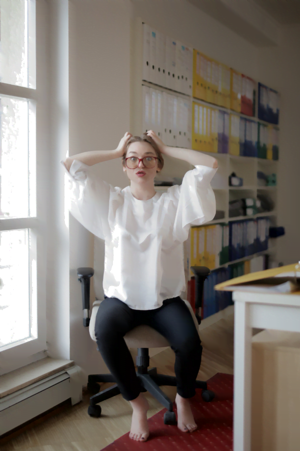 business owner behind desk pulling out her hair in front of binders full of paperwork