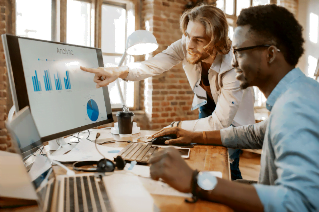 Two small business men looking at analytics on computer screen