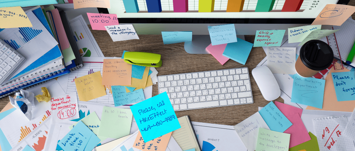 Founder's desk who needs to eliminate back office bottlenecks, with Post-it notes all over, one asking, "Please call HireEffect"